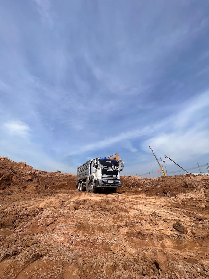 portfolio-01 A stationary truck at a construction site under a clear blue sky, showcasing industrial machinery.